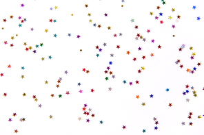 party, decoration and holidays concept - multicolored star shaped glitters on white background
