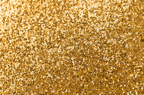 party, texture and holidays concept - golden glitters background