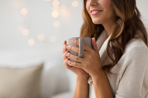 drink, christmas and hygge concept - close up of happy woman with cup of coffee or tea at home