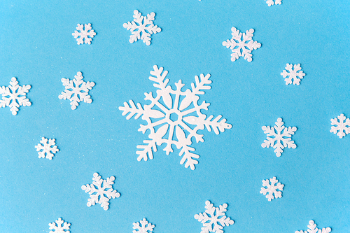 christmas, snow and winter holidays concept - white snowflake decorations on blue background