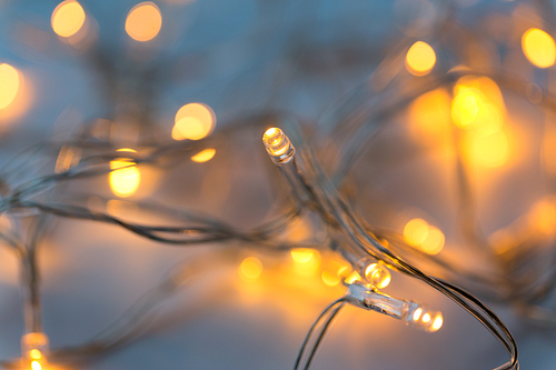 christmas, holidays and illumination concept - close up of electric garland lights