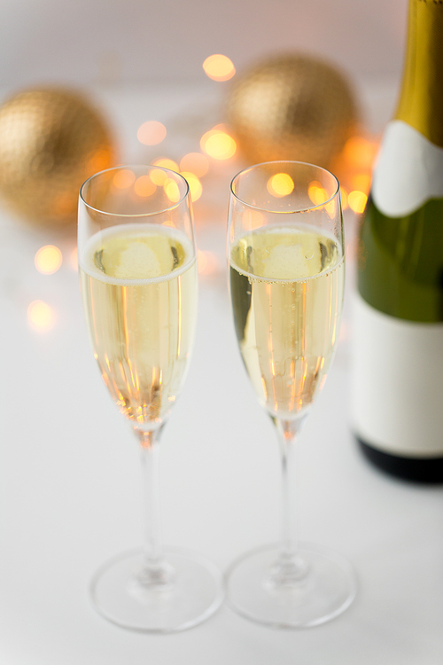 christmas, holidays and celebration concept - two glasses of champagne and decorations