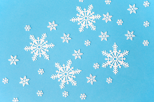 christmas, snow and winter holidays concept - white snowflake decorations on blue background