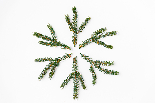 winter holidays, christmas and decorations concept - snowflake shape made of fir branches on white background