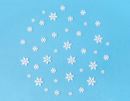 christmas, snow and winter holidays concept - white snowflake decorations on blue background