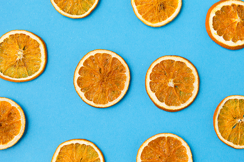 christmad, winter and citrus concept - dried orange slices on blue background