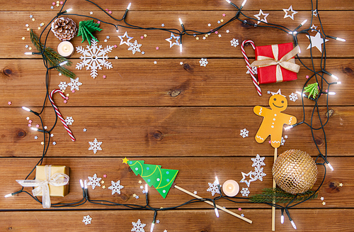 christmas and holidays concept - electric garland and decorations on wooden background