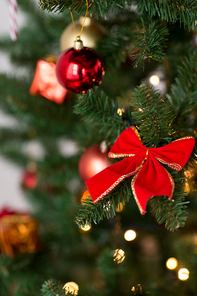winter holidays, season and luxury concept - close up of red decorations on artificial christmas tree