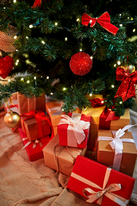 holidays, new year and celebration concept - gift boxes under decorated christmas tree at home