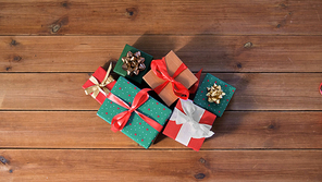 christmas, holidays and celebration concept - gift boxes on wooden boards from top