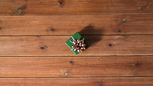 christmas, holidays and celebration concept - gift box on wooden boards from top