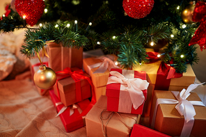 holidays, new year and celebration concept - gift boxes under decorated christmas tree at home