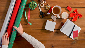 holidays, new year and christmas concept - hands setting stuff for gifts wrapping on wooden table