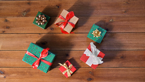 christmas, holidays and celebration concept - gift boxes on wooden boards from top