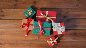 christmas, holidays and celebration concept - gift boxes on wooden boards from top