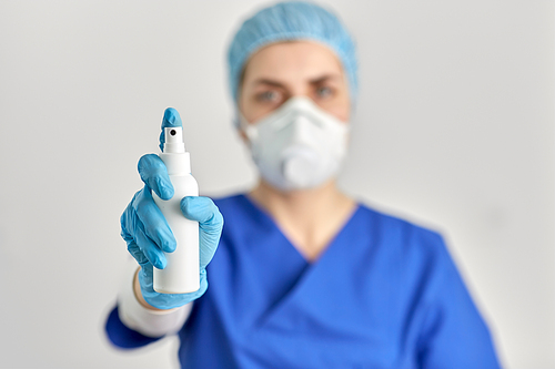 hygiene, healthcare and safety concept - close up of doctor or nurse wearing face protective medical mask or respirator for protection from virus disease with hand sanitizer