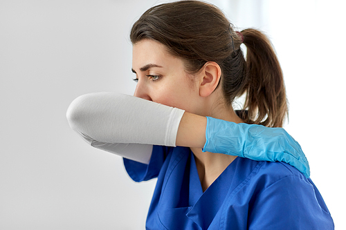 medicine, healthcare and people concept - doctor or nurse in gloves coughing covering mouth with her elbow