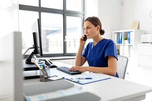 medicine, technology and healthcare concept - female doctor or nurse with computer calling on phone at hospital