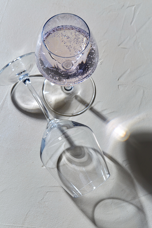 drink, alcohol and glassware concept - wine glasses dropping shadows on white surface