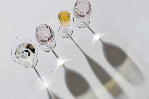 drink, alcohol and glassware concept - different wine glasses dropping shadows on white surface