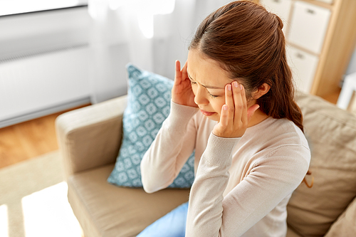 people and health concept - sick asian woman having headache at home