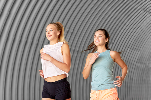 fitness, sport and healthy lifestyle concept - happy young women or female friends running outdoors