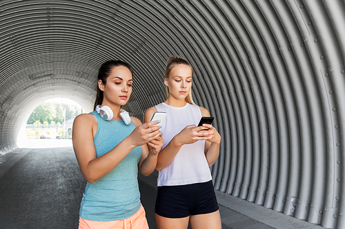 fitness, sport and healthy lifestyle concept - young women or female friends with smartphones