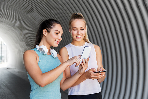 fitness, sport and healthy lifestyle concept - smiling young women or female friends with smartphones