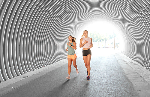 fitness, sport and healthy lifestyle concept - young women or female friends running outdoors