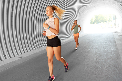 fitness, sport and healthy lifestyle concept - young women or female friends running outdoors