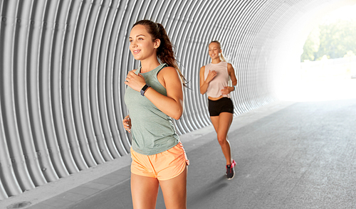 fitness, sport and healthy lifestyle concept - young women or female friends running outdoors