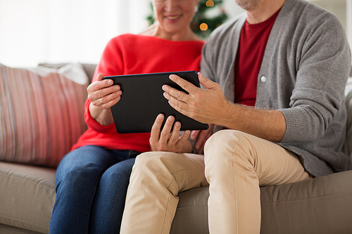 christmas, holidays and people concept - close up of happy smiling senior couple with tablet pc computer at home
