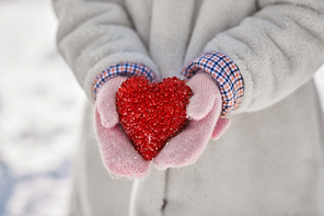 love, christmas and valentine's day concept - close up of little girl holding heart in winter