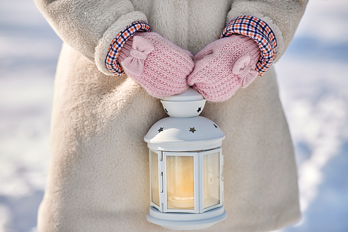 childhood and holidays concept - close up of little girl holding christmas lantern in winter