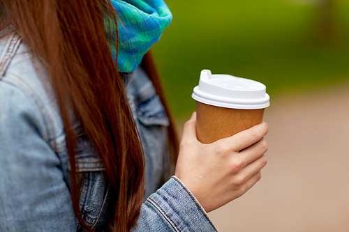 people and drinks concept - close up of young woman drinking takeaway coffee