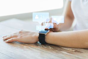 modern technology and people concept - close up of woman hands wearing smart watch with social media icons