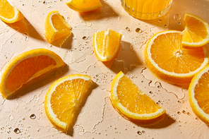 drink, detox and vitaminic concept - glass of juice and orange slices on wet table