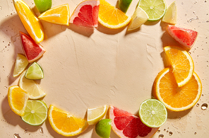 summer, vegetarian and vitaminic concept - frame of slices of chopped different citrus fruits on wet surface