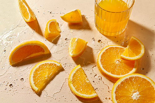 drink, detox and vitaminic concept - glass of juice and orange slices on wet table