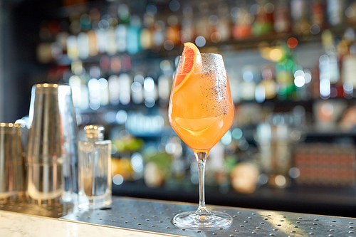 alcohol drinks and luxury concept - glass of grapefruit cocktail at bar