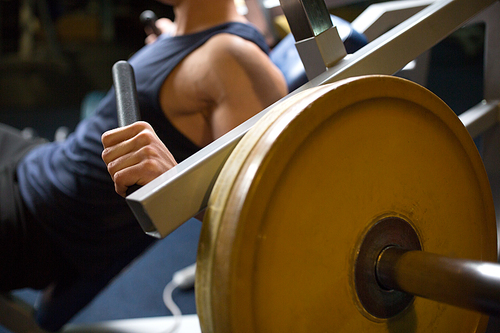 sport, fitness and people concept - close up of man exercising on gym machine
