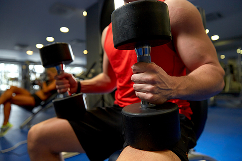 sport, fitness and healthy lifestyle concept - close up of man with dumbbells exercising in gym
