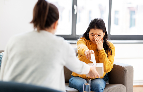 psychology and mental therapy concept - young asian woman patient crying at psychotherapy session