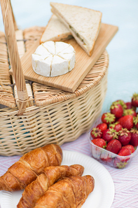 leisure concept - picnic basket, food and wine glasses on blanket
