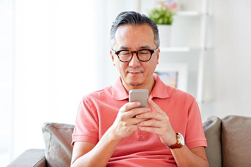 technology, people, lifestyle and communication concept - man with smartphone sitting on sofa at home