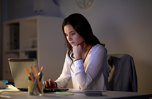 business, people, deadline and technology concept - businesswoman with laptop at night office