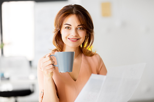 business and people concept - businesswoman with papers at working office and drinking coffee