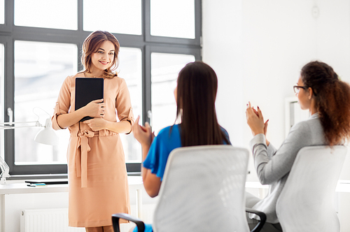 business, success and people concept - businesswomen applauding to colleague with tablet pc computer at office