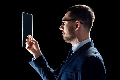 business, people, augmented reality and modern technology concept - businessman in suit working with transparent tablet pc computer over black backgrouns
