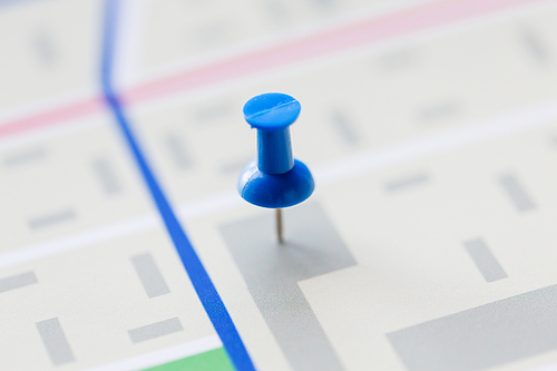 cartography, location and navigation concept - close up of map or city plan with pin